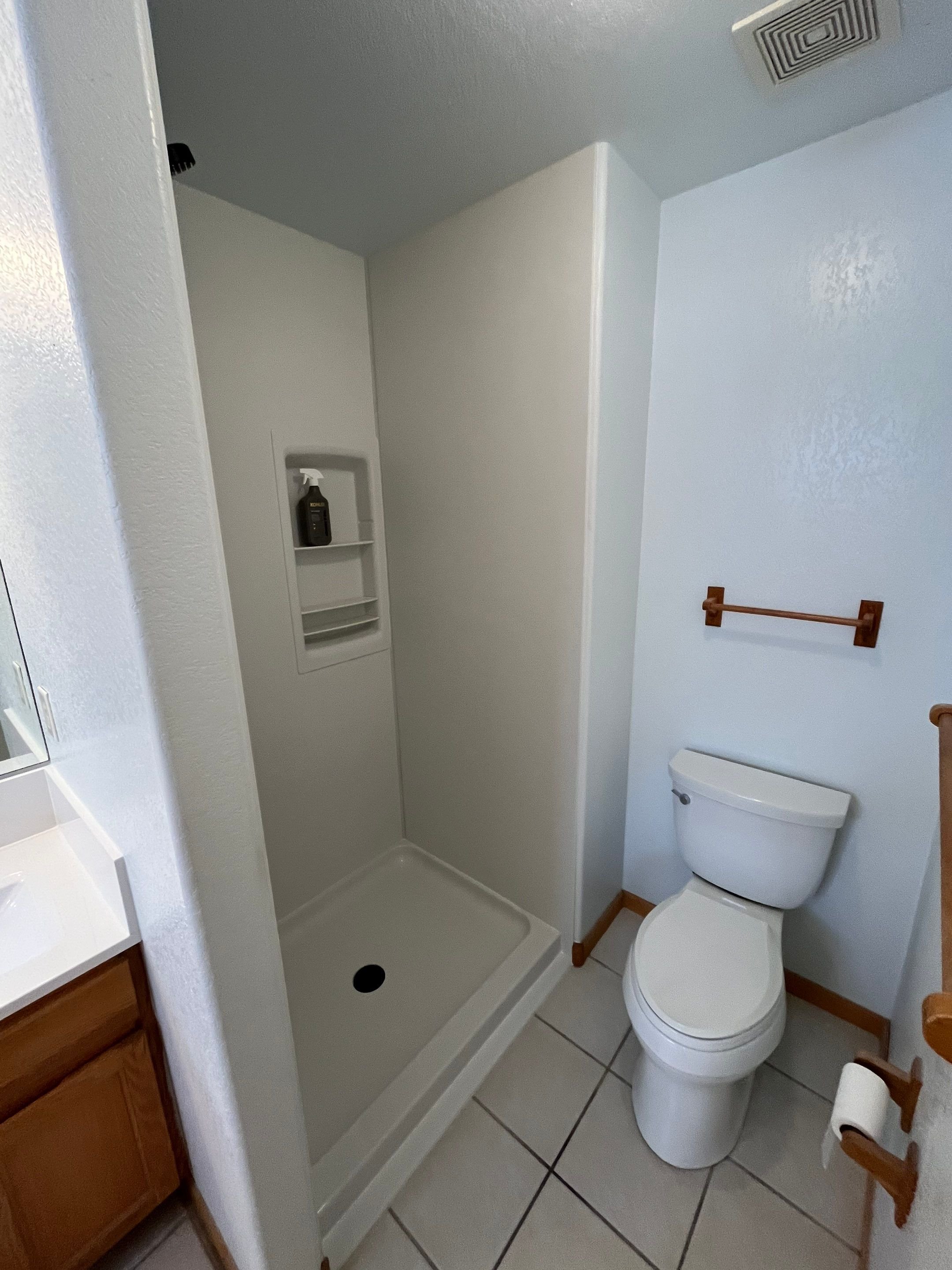 Shower remodel completed on 8th Street in Loveland, CO, featuring a compact walk-in shower with integrated shelving, improved ventilation, and low-maintenance wall panels.
