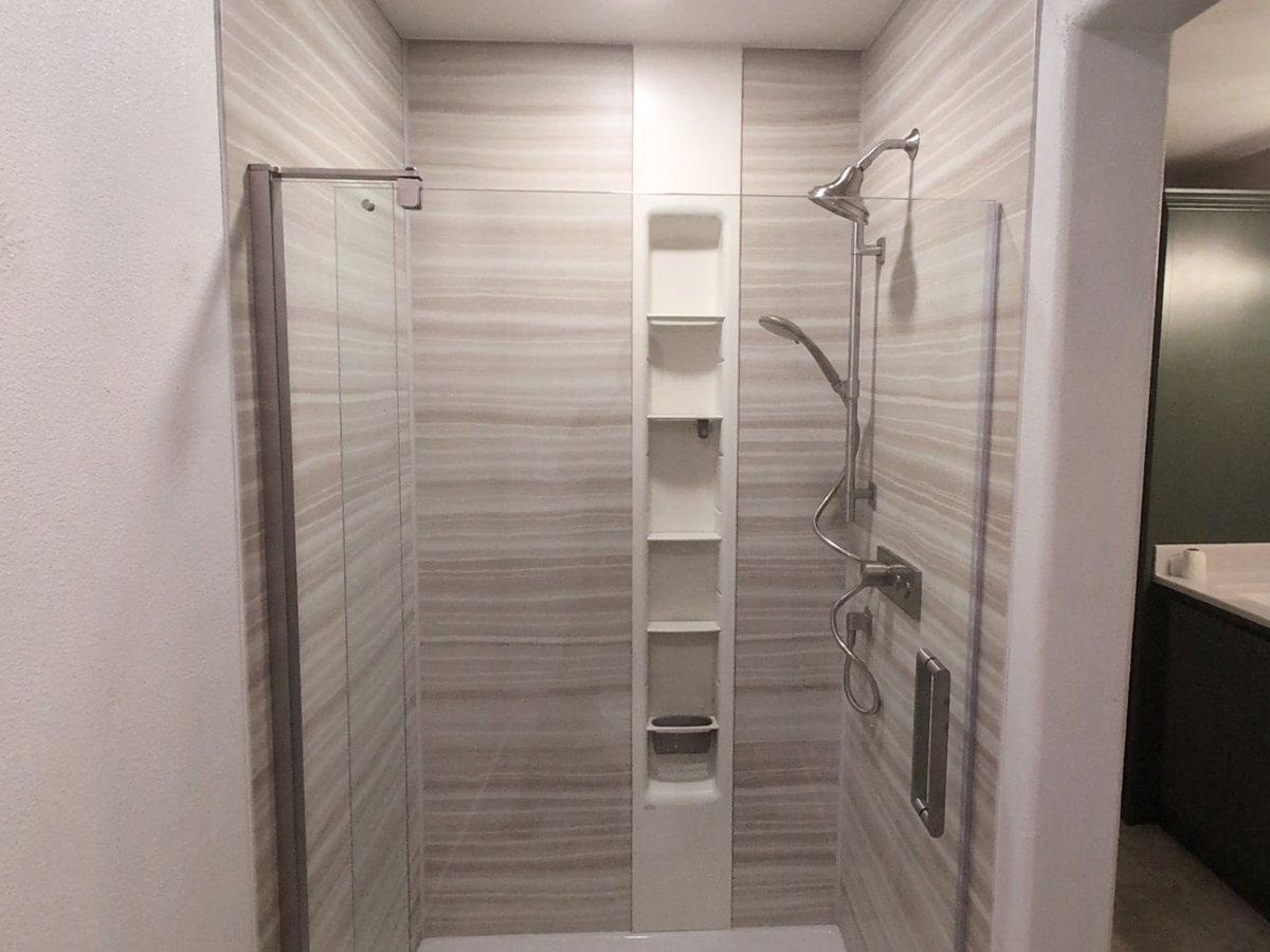 Completed walk-in shower with KOHLER wall panels, glass enclosure, and brushed nickel fixtures after a primary bathroom remodel in Steamboat Springs, Colorado.