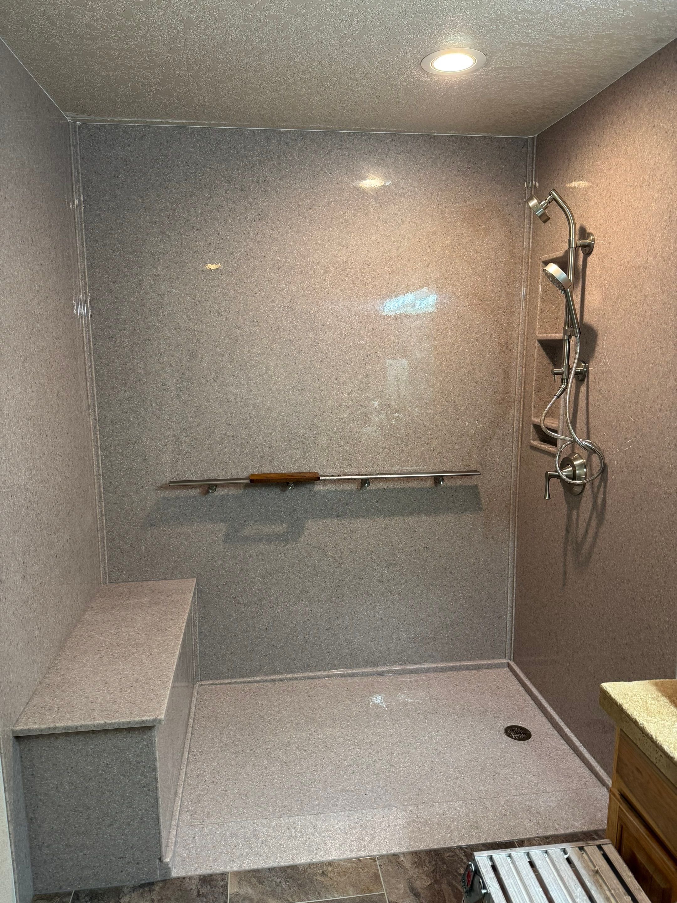 Curbless walk-in shower remodel on Animus Court in Grand Junction with slip-resistant flooring, built-in bench, grab bar, and low-maintenance wall panels.