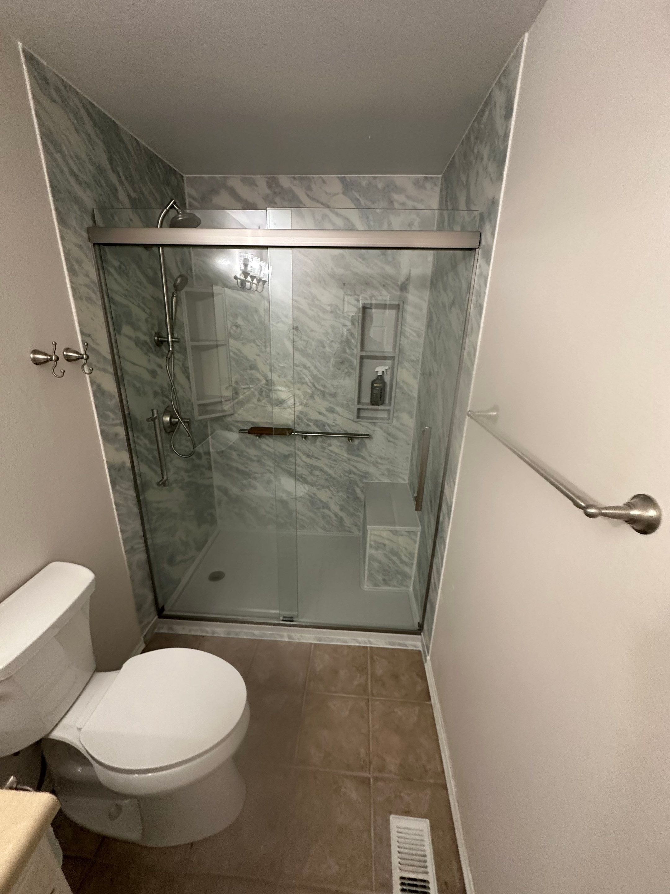 Walk-in shower remodel with marble-look wall panels and glass enclosure in a Durango, Colorado bathroom