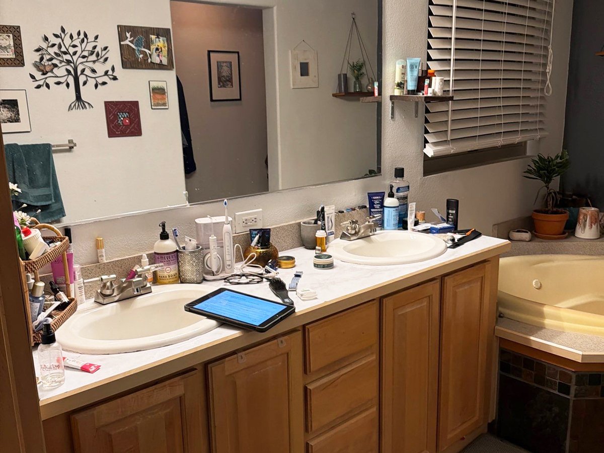 Before photo of the primary bathroom with a double vanity and built-in soaking tub in a Steamboat Springs, Colorado home before remodeling.