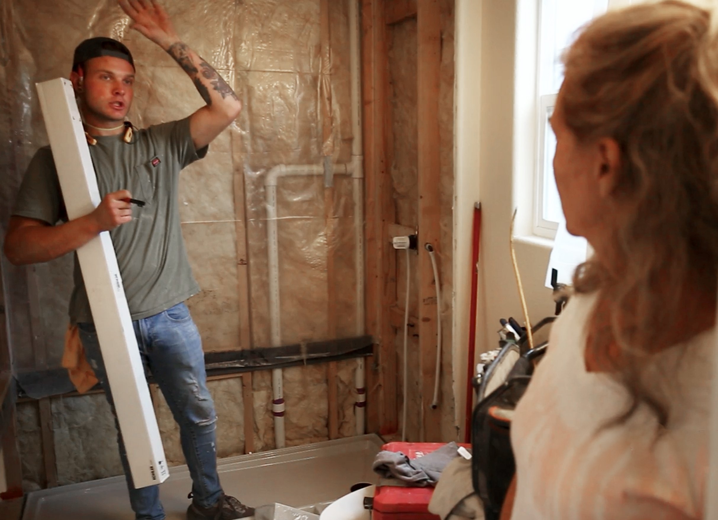 HomePride Bath contractor explaining exposed wall plumbing and insulation to Colorado homeowner during bathroom remodel consultation before demolition