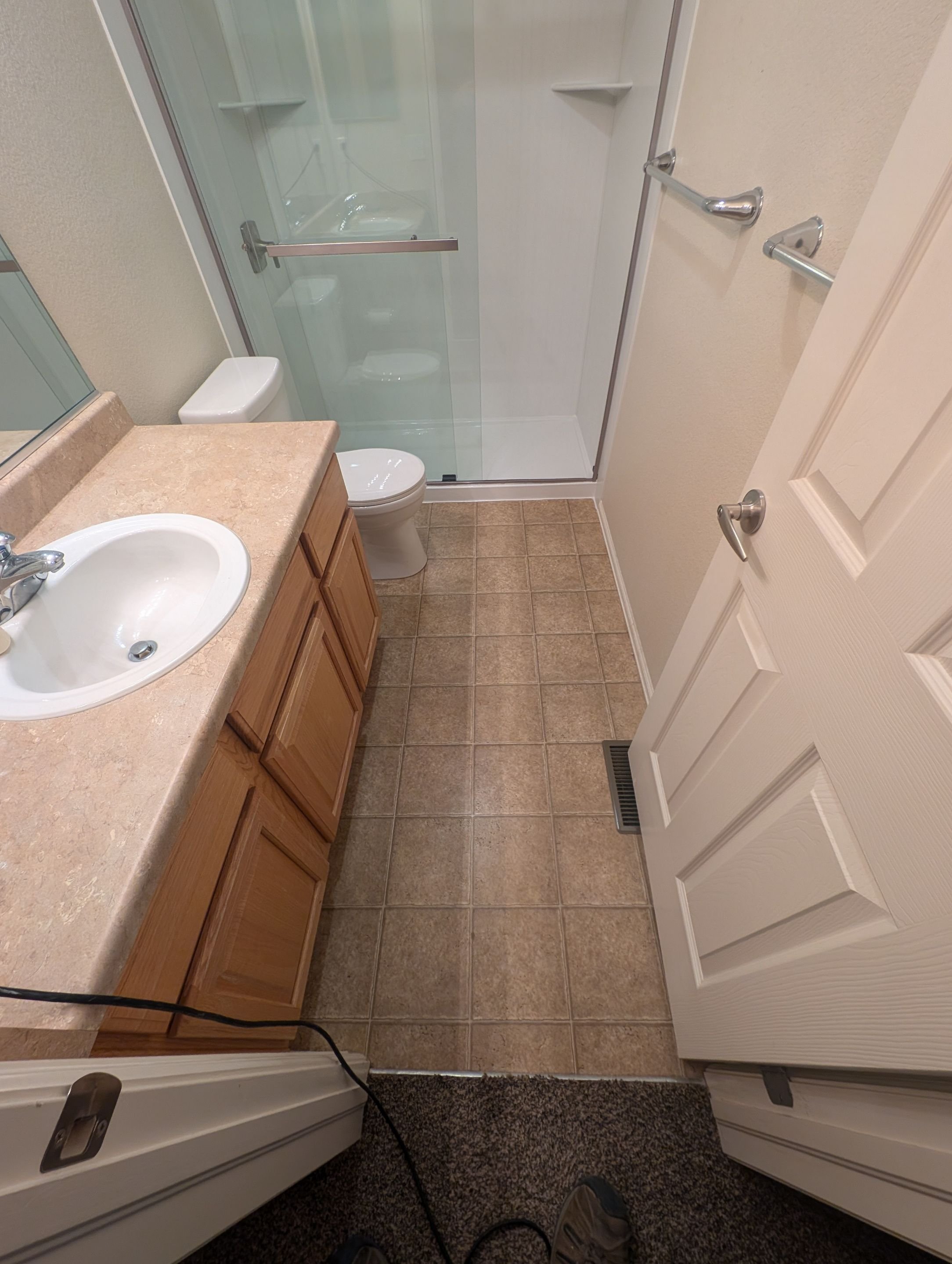 Small bathroom remodel in Littleton, CO on Burgundy Drive with a walk-in shower, low-maintenance wall system, updated flooring, and space-saving layout.