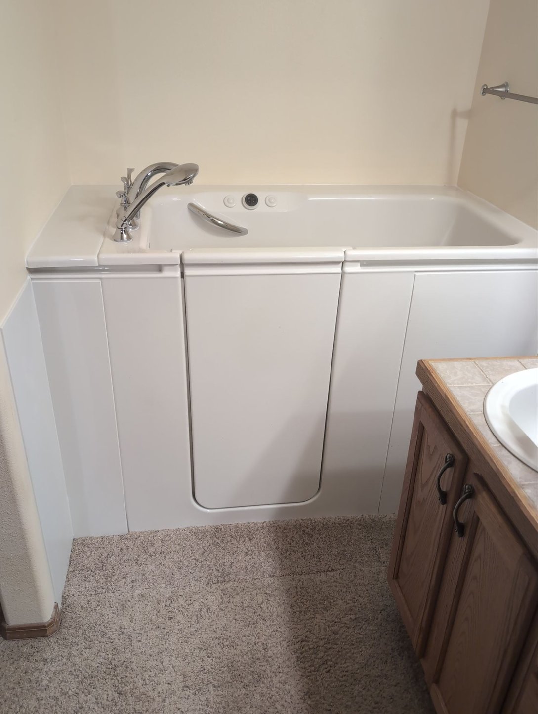 Corner-installed KOHLER walk-in tub in a Colorado Springs home, framed by large windows and tile floors.