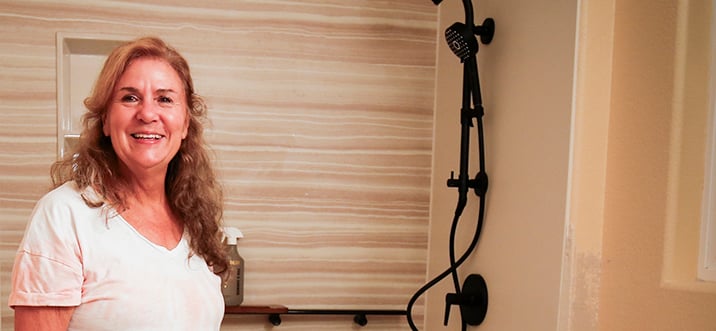 Fraud Specialist Carol Hee standing in her bathroom built by HomePride