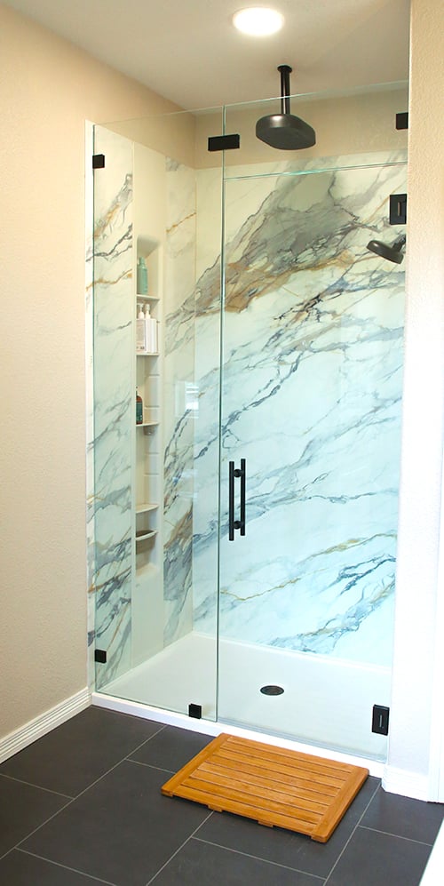 Castle Rock bathroom remodel with glass walk-in shower and marble-look LuxStone walls