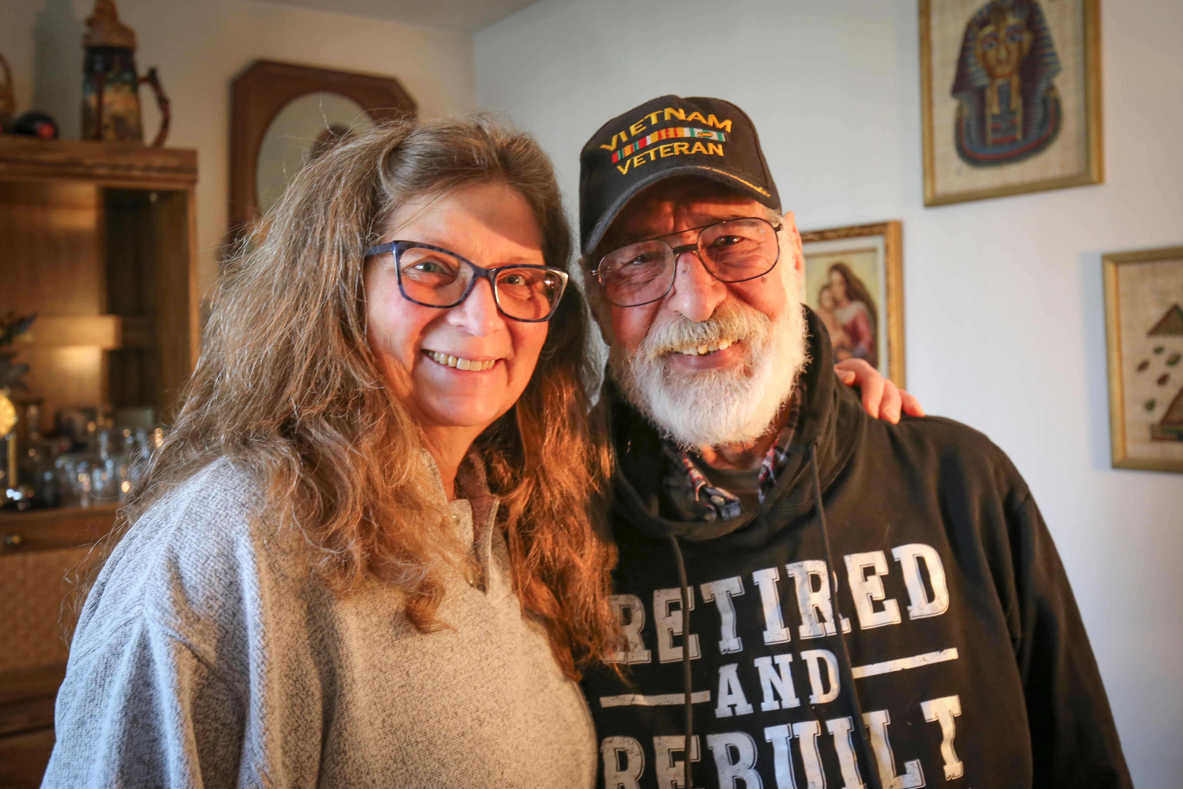 Cheryl and George Neama standing together in their Colorado Springs home after completing a walk-in shower remodel designed for safety and aging in place.