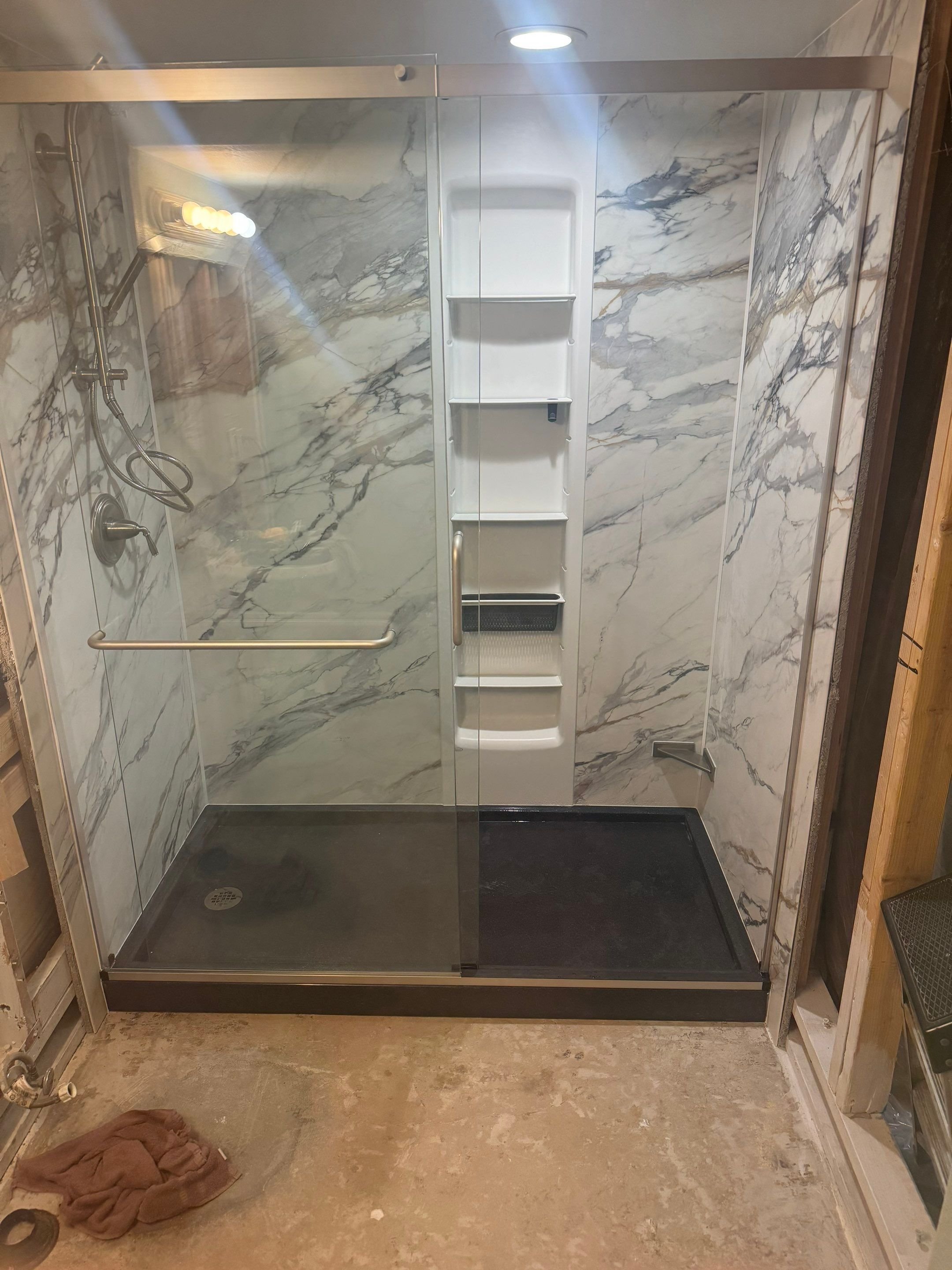 Bathroom remodel on Descendant Drive in Fountain, Colorado showing a modern shower with marble-look wall systems and updated fixtures
