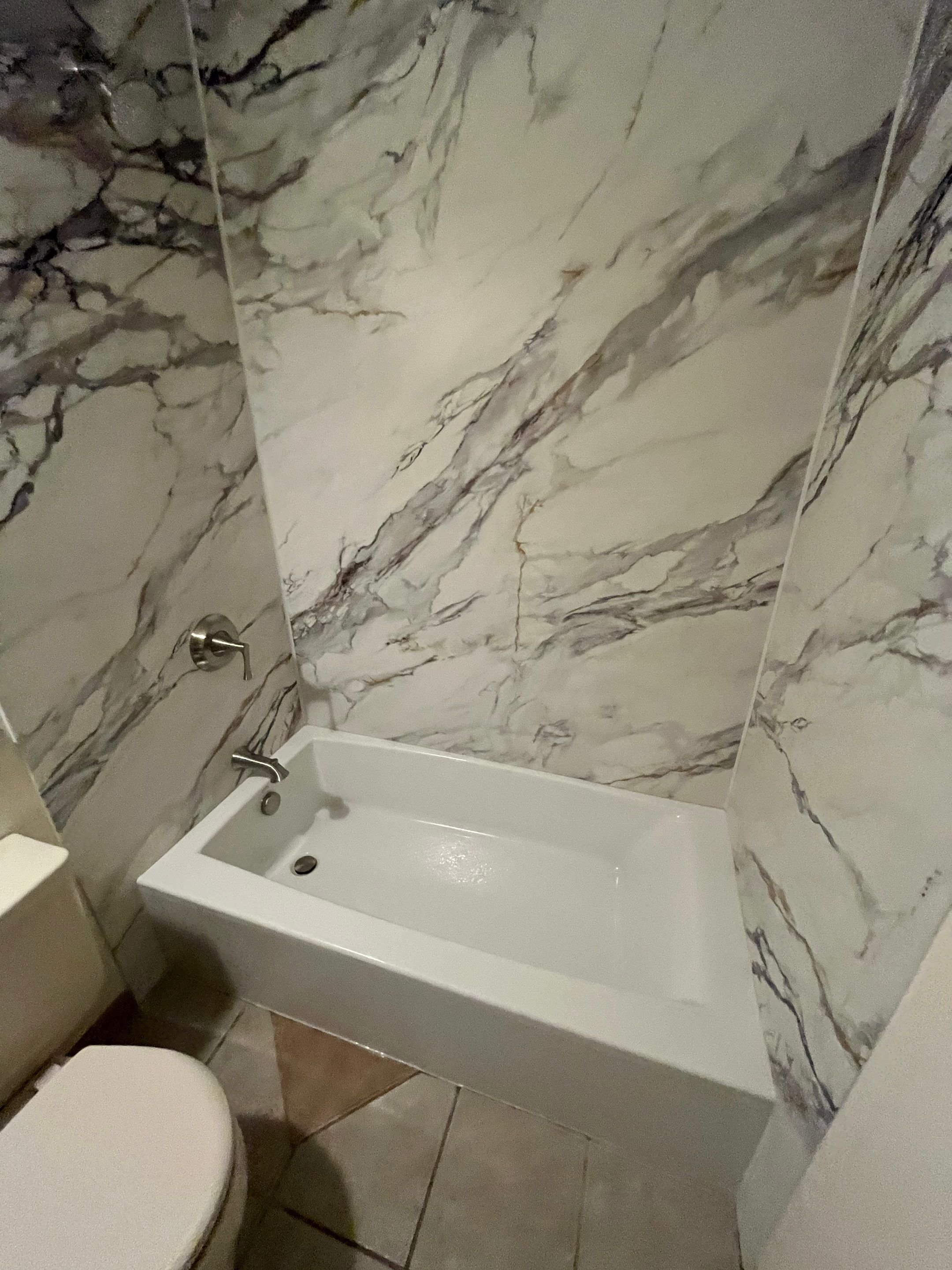 A new Kphler tub and LuxStone wall panels in Calacatta Gold, installed on E Powers Lane in Centennial, Colorado