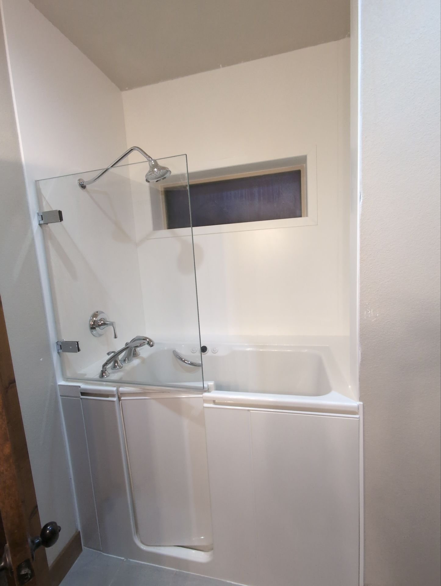 Barrier-free walk-in shower on E Riding Club Road in Cheyenne, WY with bench seating, grab bars, and easy-clean wall system