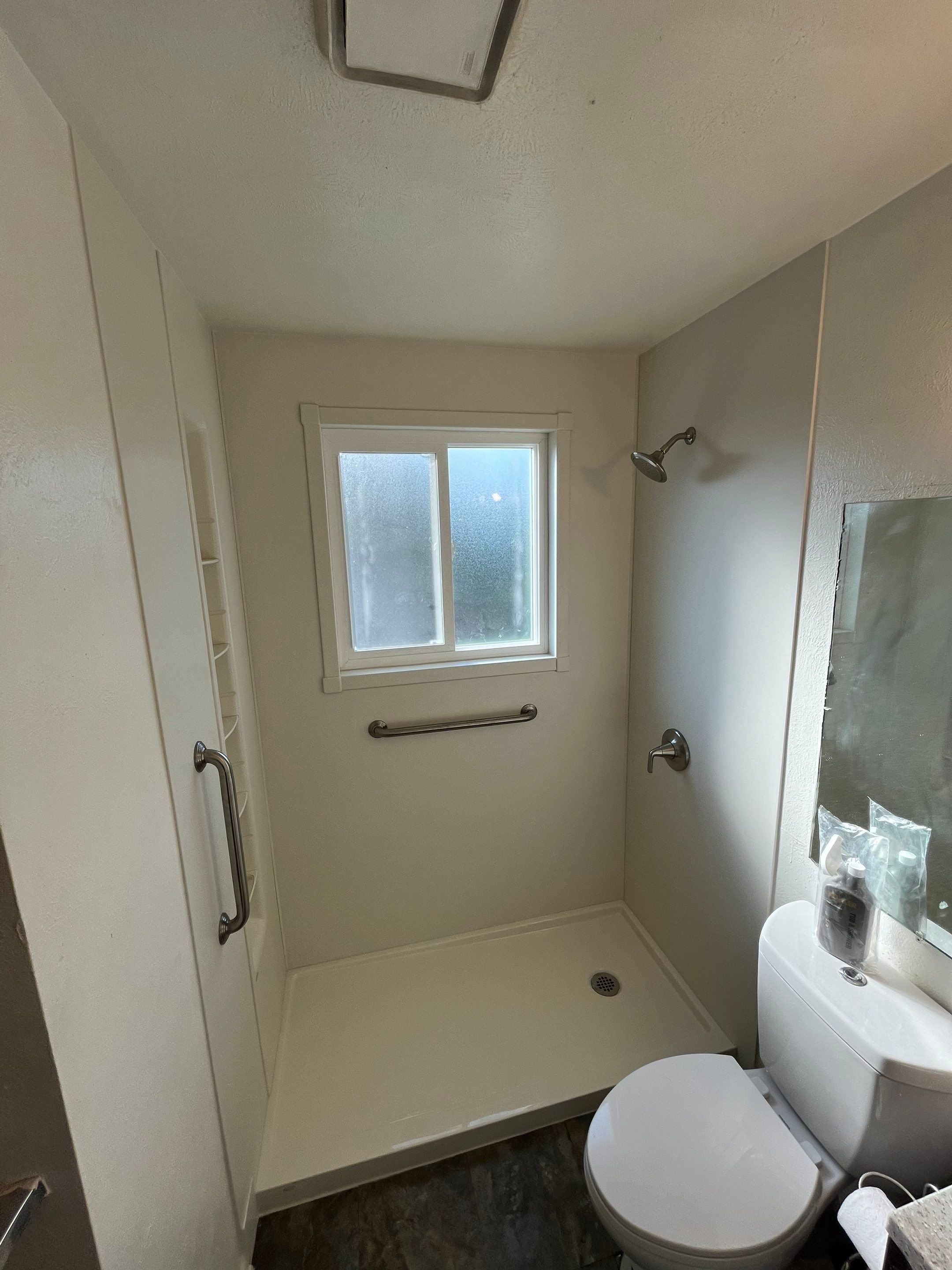 Tub-to-shower conversion on Fairplay Way in Denver with low-step shower base, safety grab bars, and simple, easy-to-clean wall system