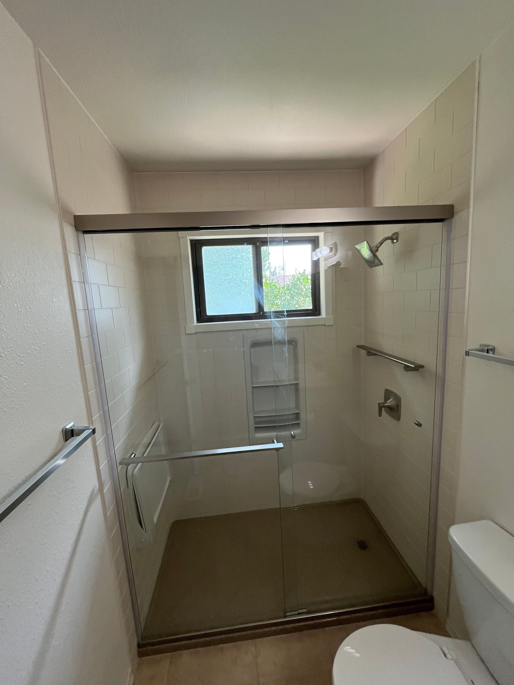 Bathroom shower remodel in Pueblo, Colorado on Gradishar Place with upgraded ventilation, safety grab bars, and easy-clean wall panels
