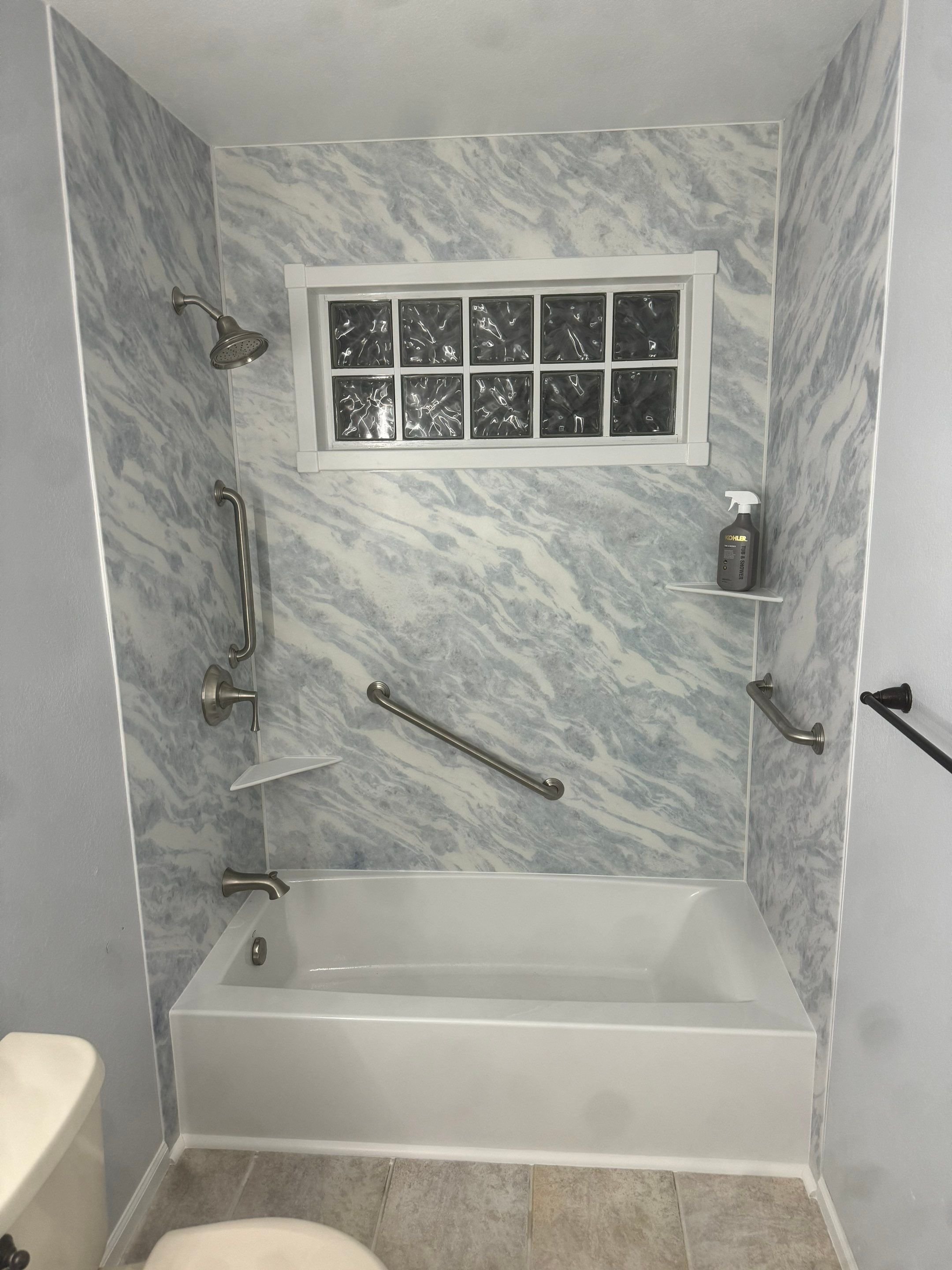 Bathroom renovation in Littleton, CO on Greenwich Street showcasing a modern shower system, updated vanity, and improved lighting in an older home.