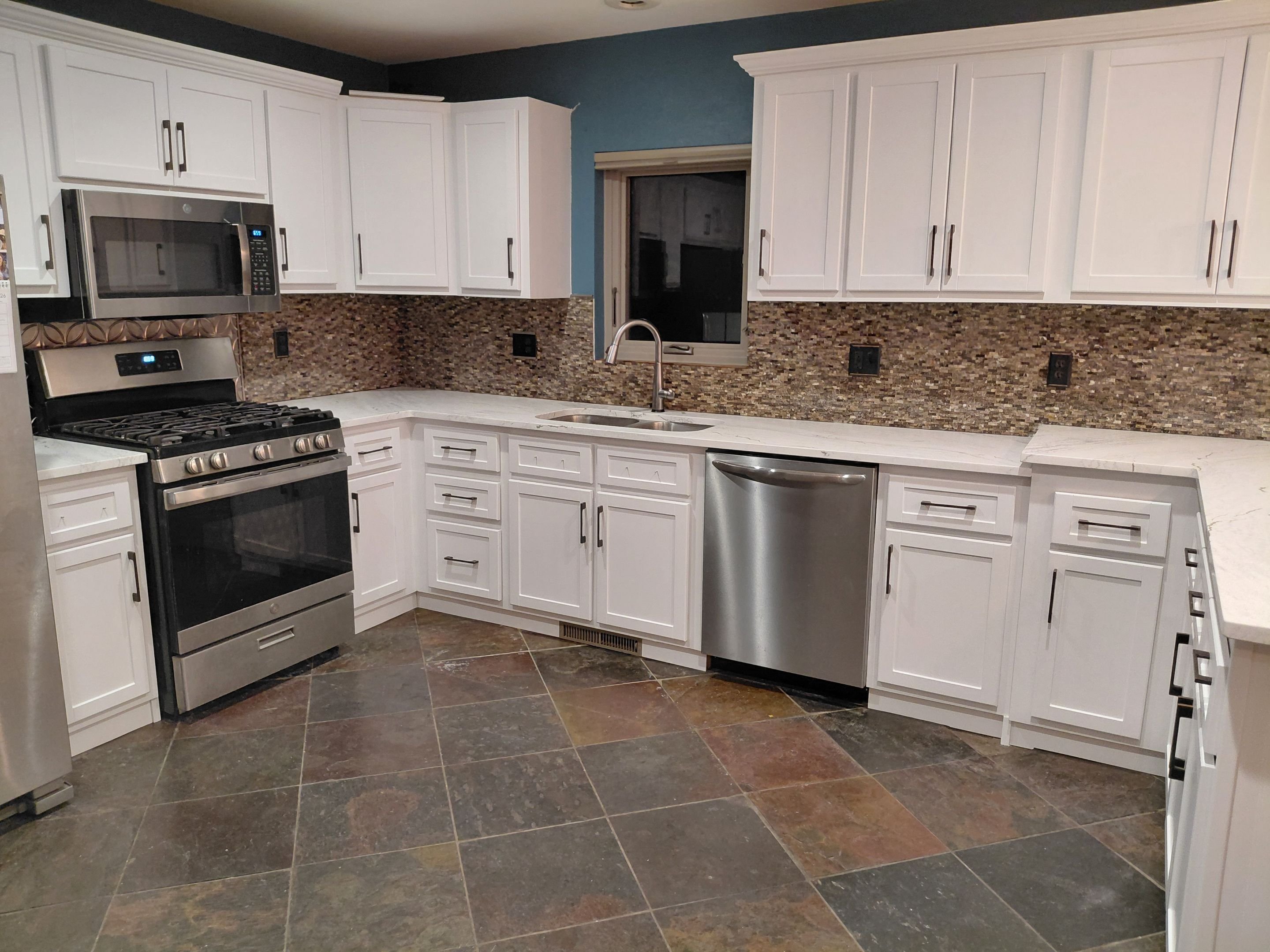Finished kitchen cabinet restyling in Steamboat Springs, Colorado, featuring white Shaker-style cabinets and updated hardware