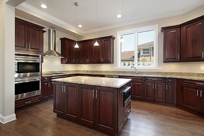 Dark cherry kitchen cabinet restyling in Highlands Ranch, CO with granite countertops and center island