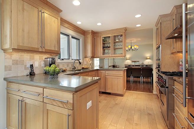 Light maple kitchen cabinet restyling in Loveland, CO with quartz countertops and under-cabinet lighting