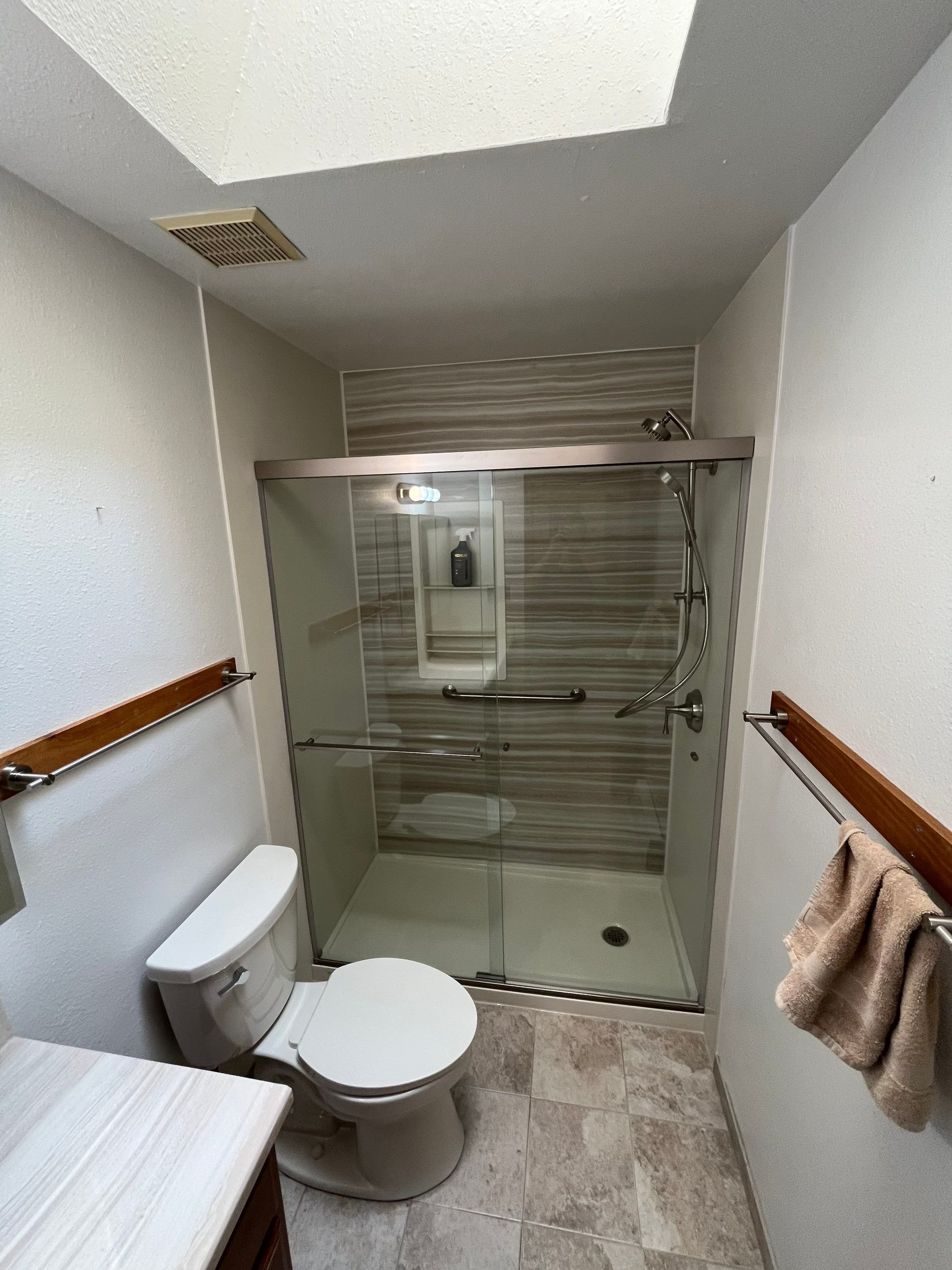 Tub-to-shower conversion with low-maintenance wall panels and grab bar in a Durango bathroom remodel