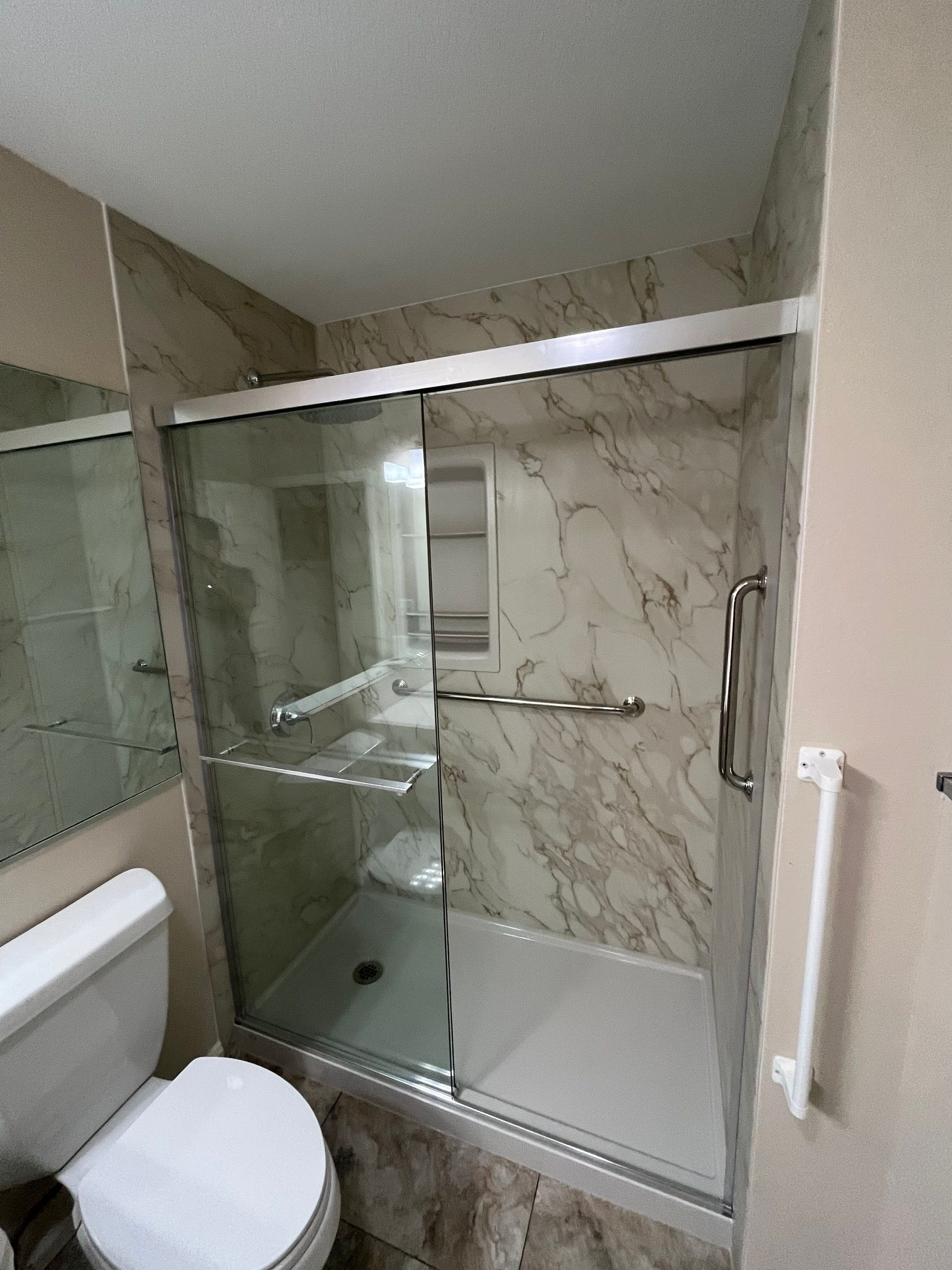 Walk-in shower remodel on Evanstar Court in Fort Collins with grab bars, built-in shelving, and slip-resistant shower base