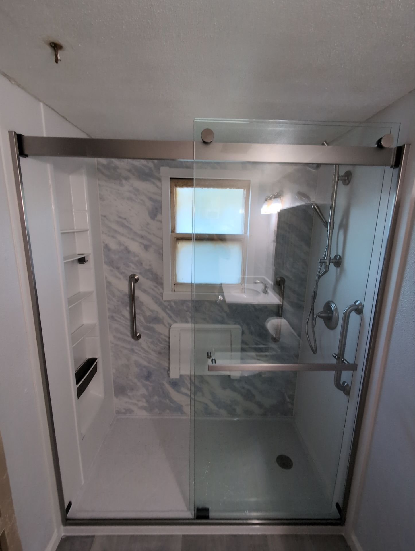 Pueblo Colorado bathroom remodel on Cactus Street featuring glass shower enclosure, grab bars, and non-porous wall system