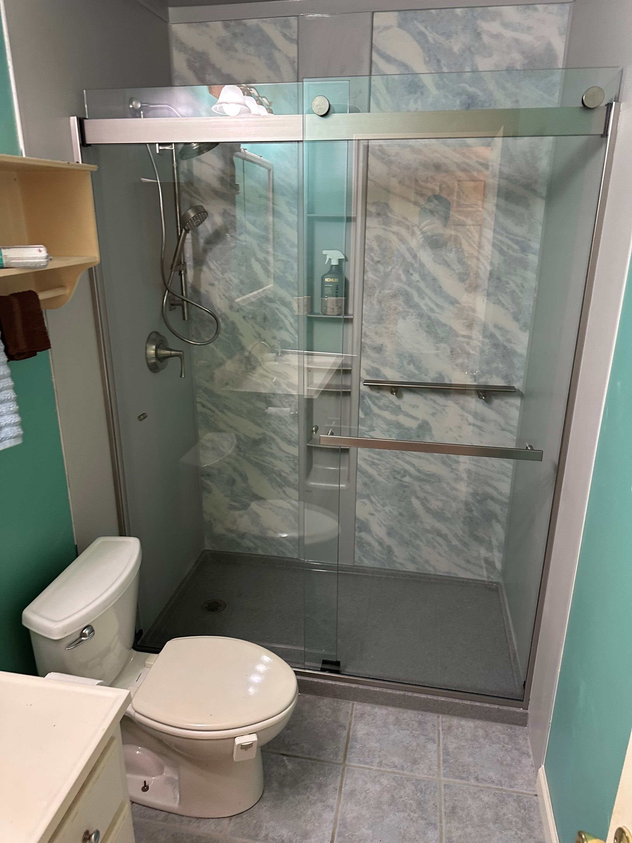Thornton bathroom renovation on Dexter Place with a tub-to-shower conversion, built-in shelving, and moisture-resistant wall panels designed for easy maintenance.