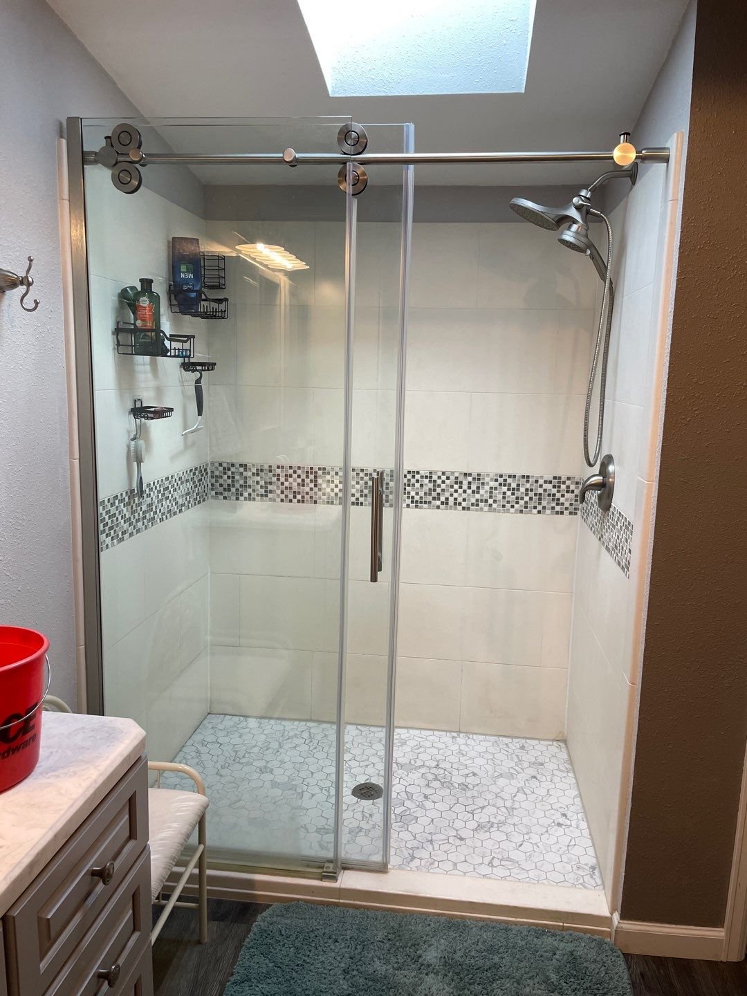 Frameless glass shower with mosaic tile band and dual shower heads