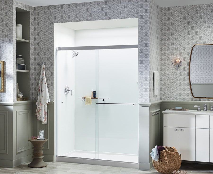 Modern walk-in shower with sliding glass doors, KOHLER fixtures, and elegant white bathroom design.