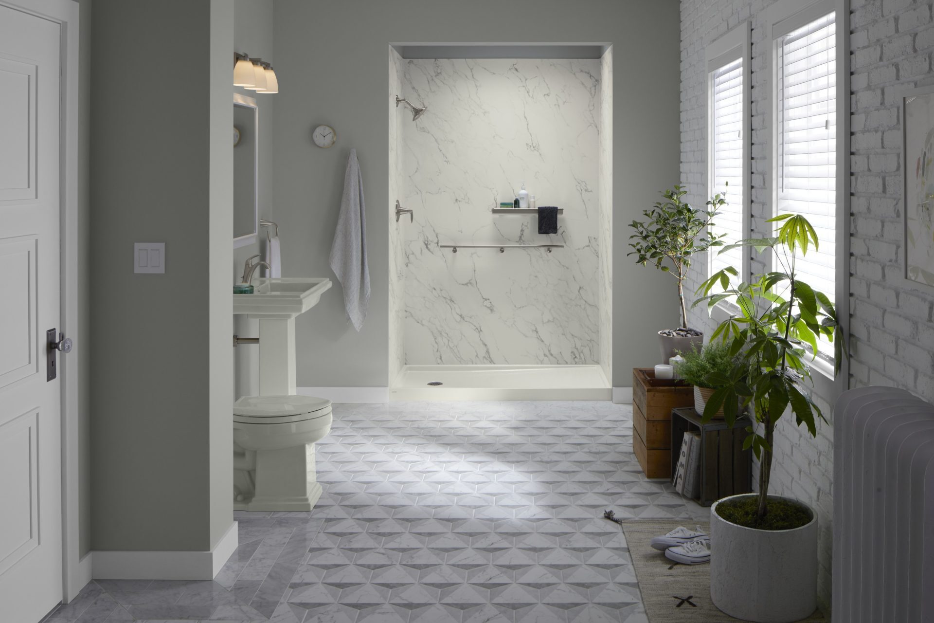 Modern bathroom with a walk-in shower featuring marble-style solid surface walls, pedestal sink, and natural light from large windows.