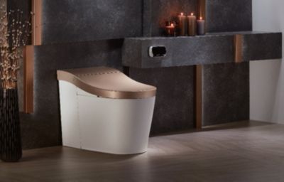 Kohler Innate smart shower toilet with bronze lid and modern black tile wall—showcasing sleek, hands-free luxury and aging-in-place comfort.
