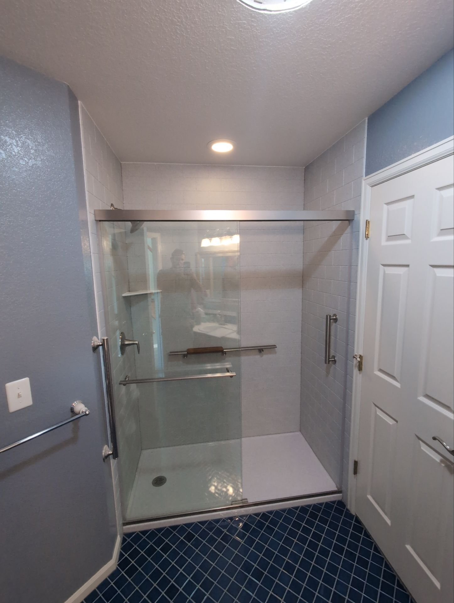 Tub-to-shower remodel completed on Jordan Drive in Loveland featuring a frameless glass enclosure, upgraded fixtures, and moisture-resistant wall panels.