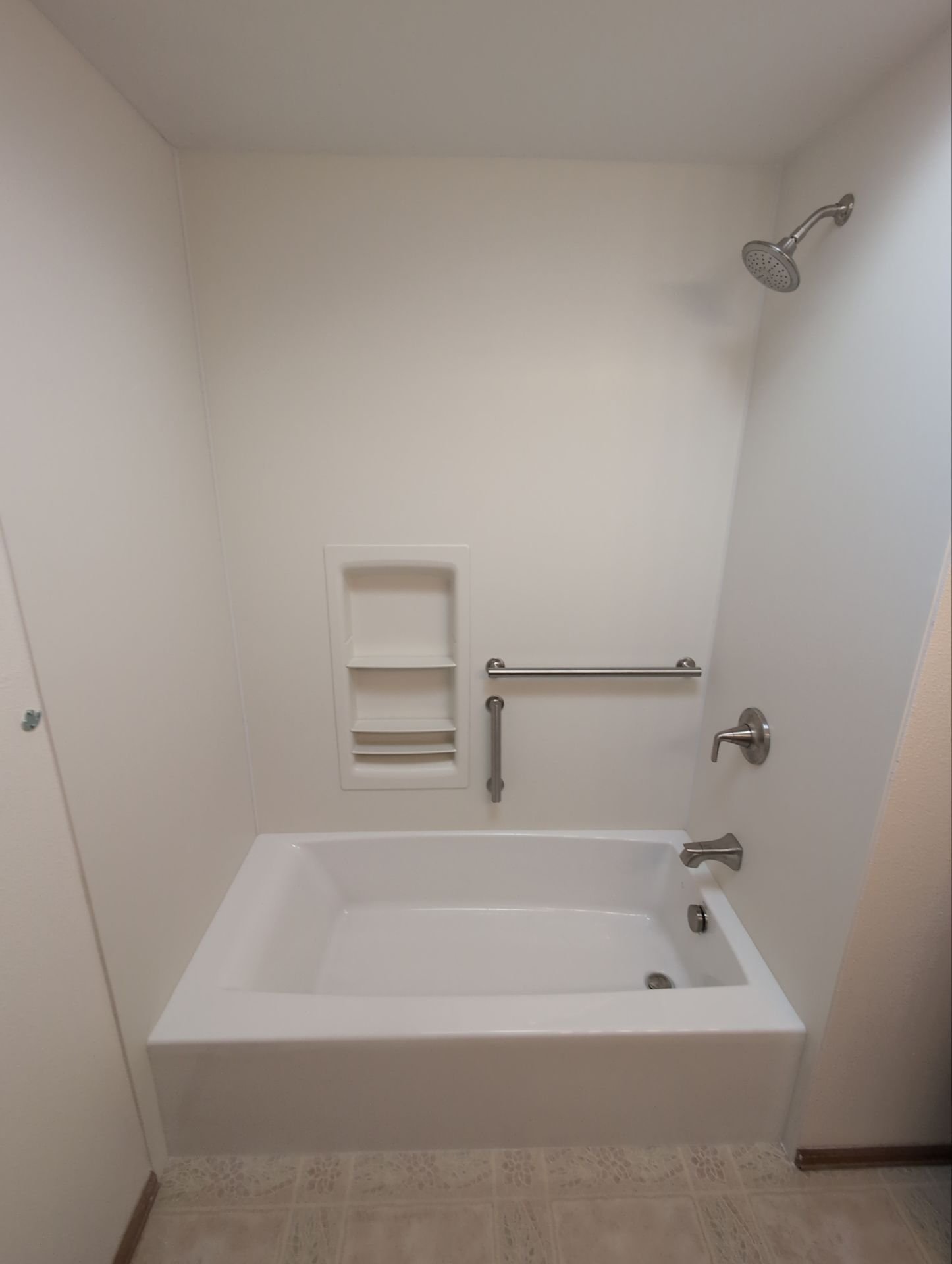 Bathroom renovation on Lochwood Drive in Fort Collins showing a glass-enclosed shower with marble-style walls and improved ventilation