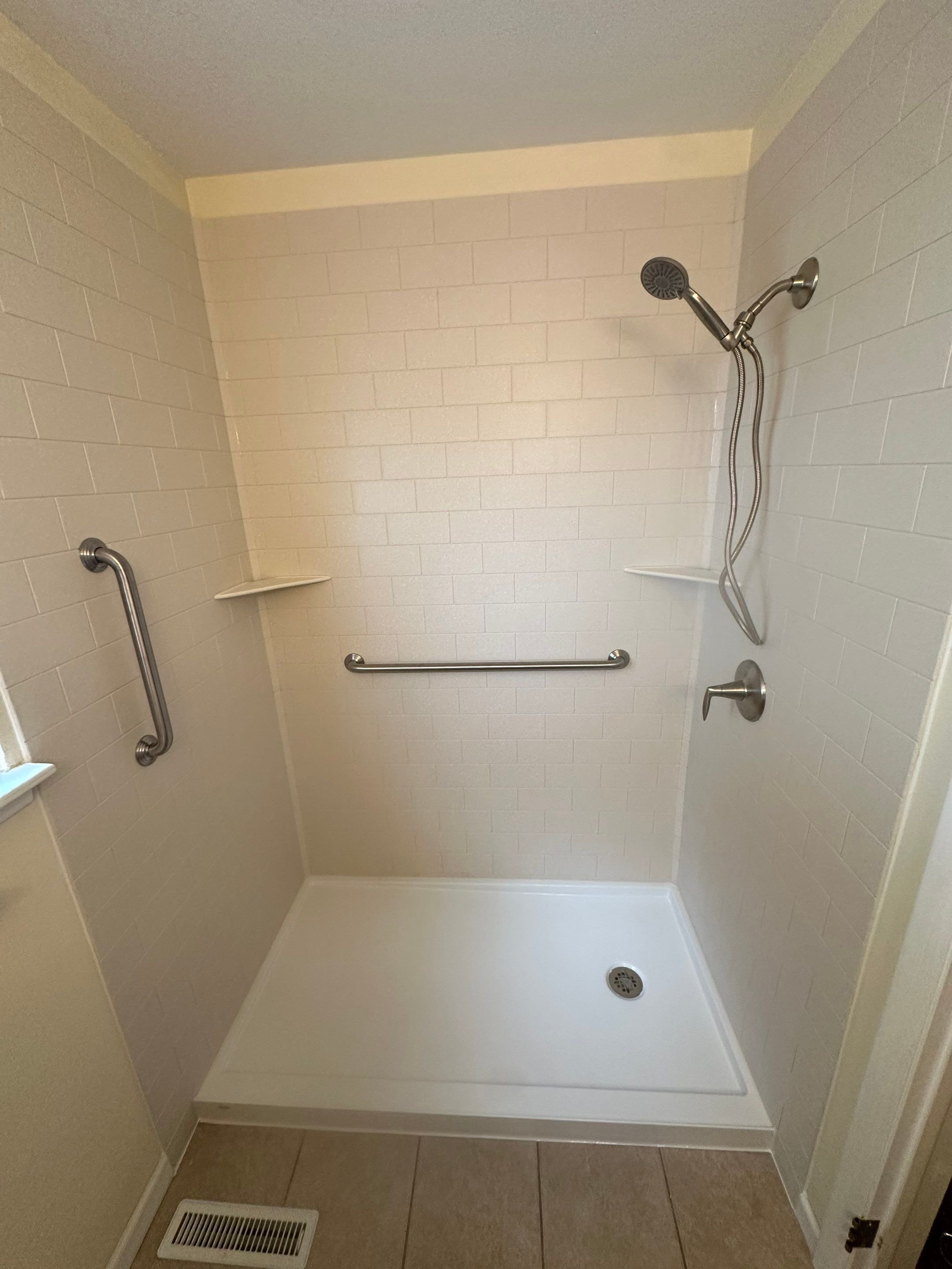 Shower remodel in Pueblo, Colorado on Lynwood Lane featuring low-maintenance wall panels, corner shelves, and updated plumbing fixtures