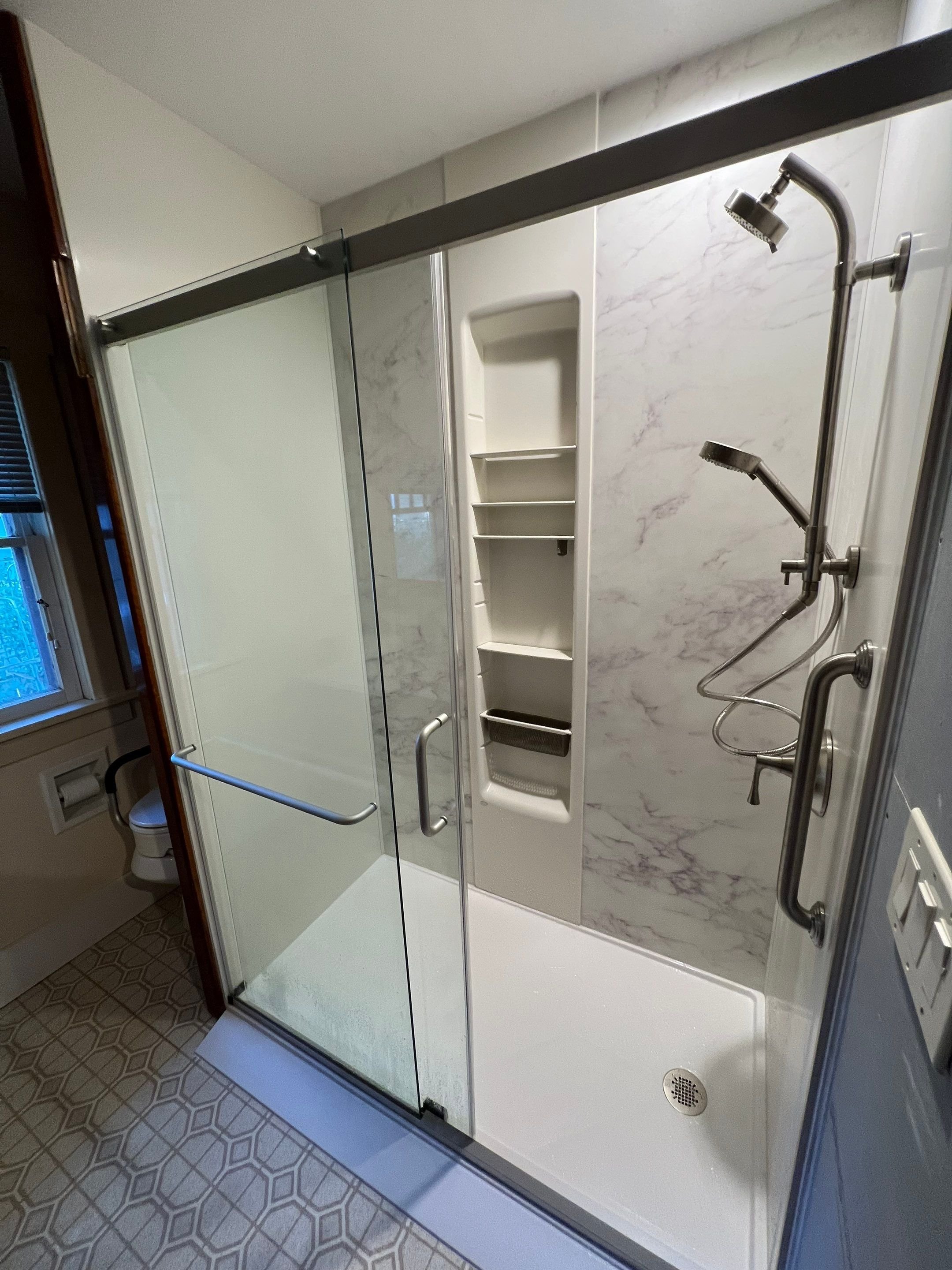 Fort Collins bathroom remodel on Pearl Street featuring a clean white tub surround with safety grab bars and easy-to-clean surfaces