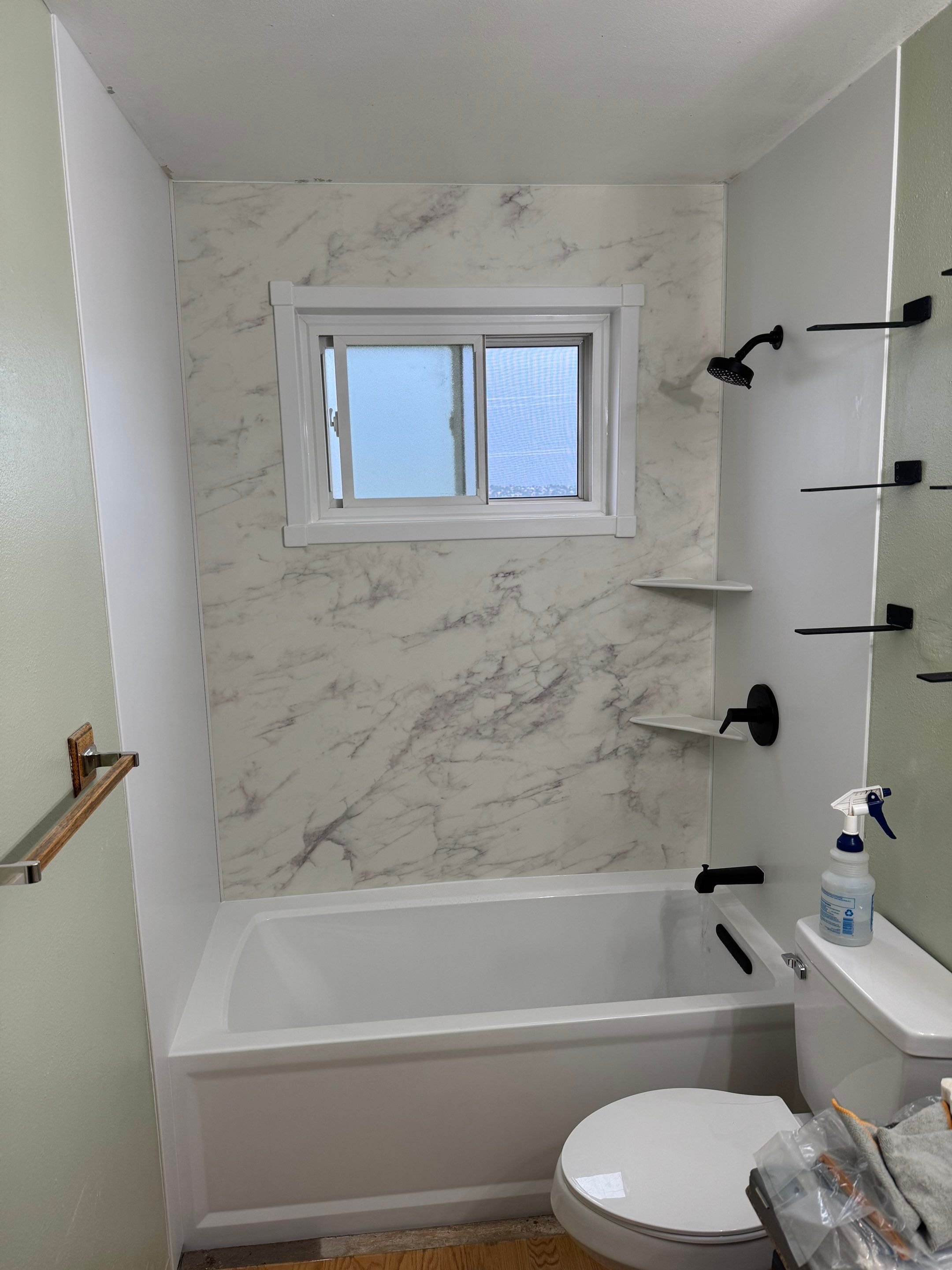Walk-in shower remodel in a Colorado Springs bathroom on Ramblewood Drive featuring granite-look walls, built-in bench, sliding glass doors, and accessibility upgrades