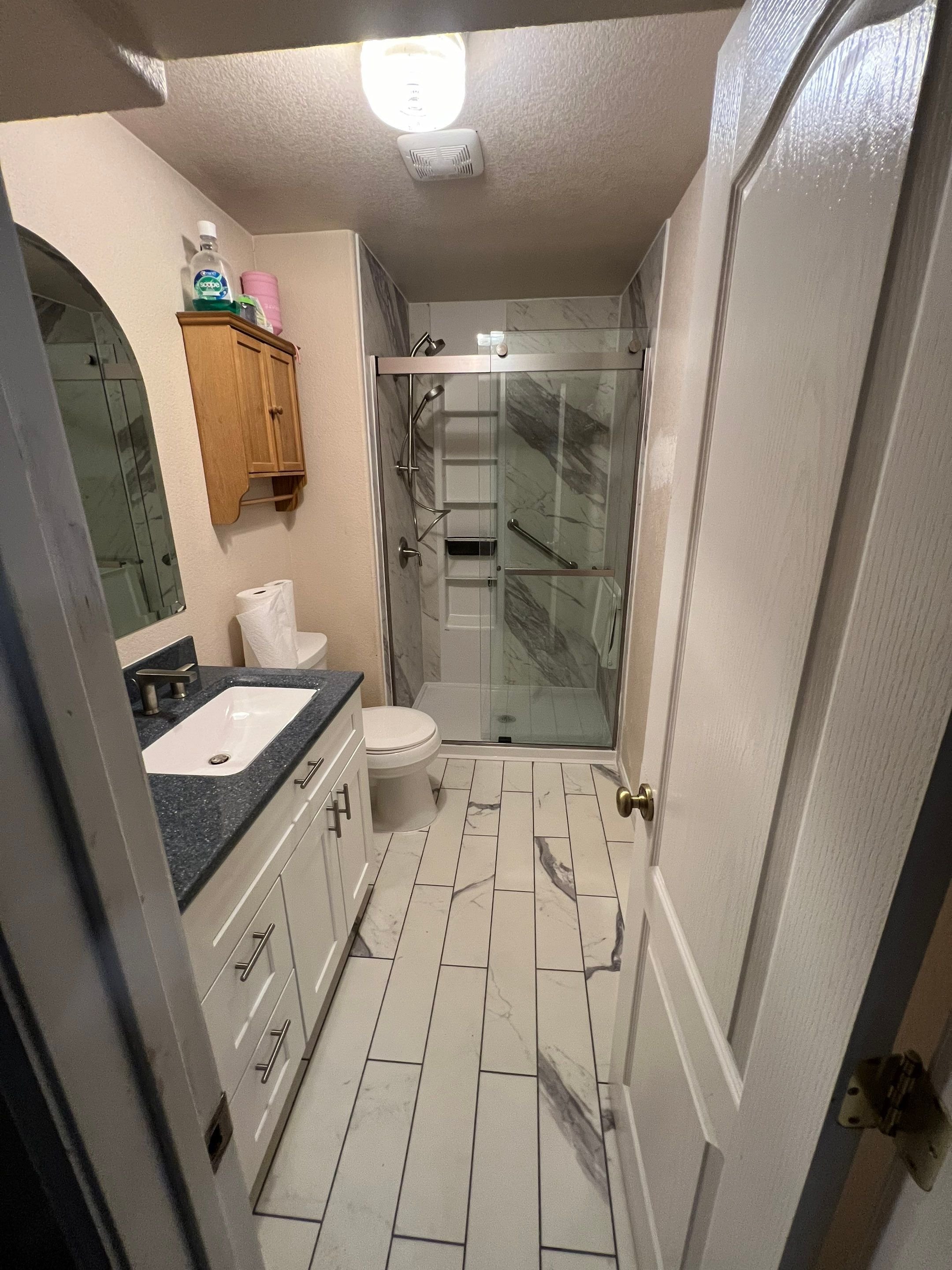 Full bathroom remodel on Reunion Circle in Fountain, Colorado featuring a walk-in shower, updated vanity, and durable flooring