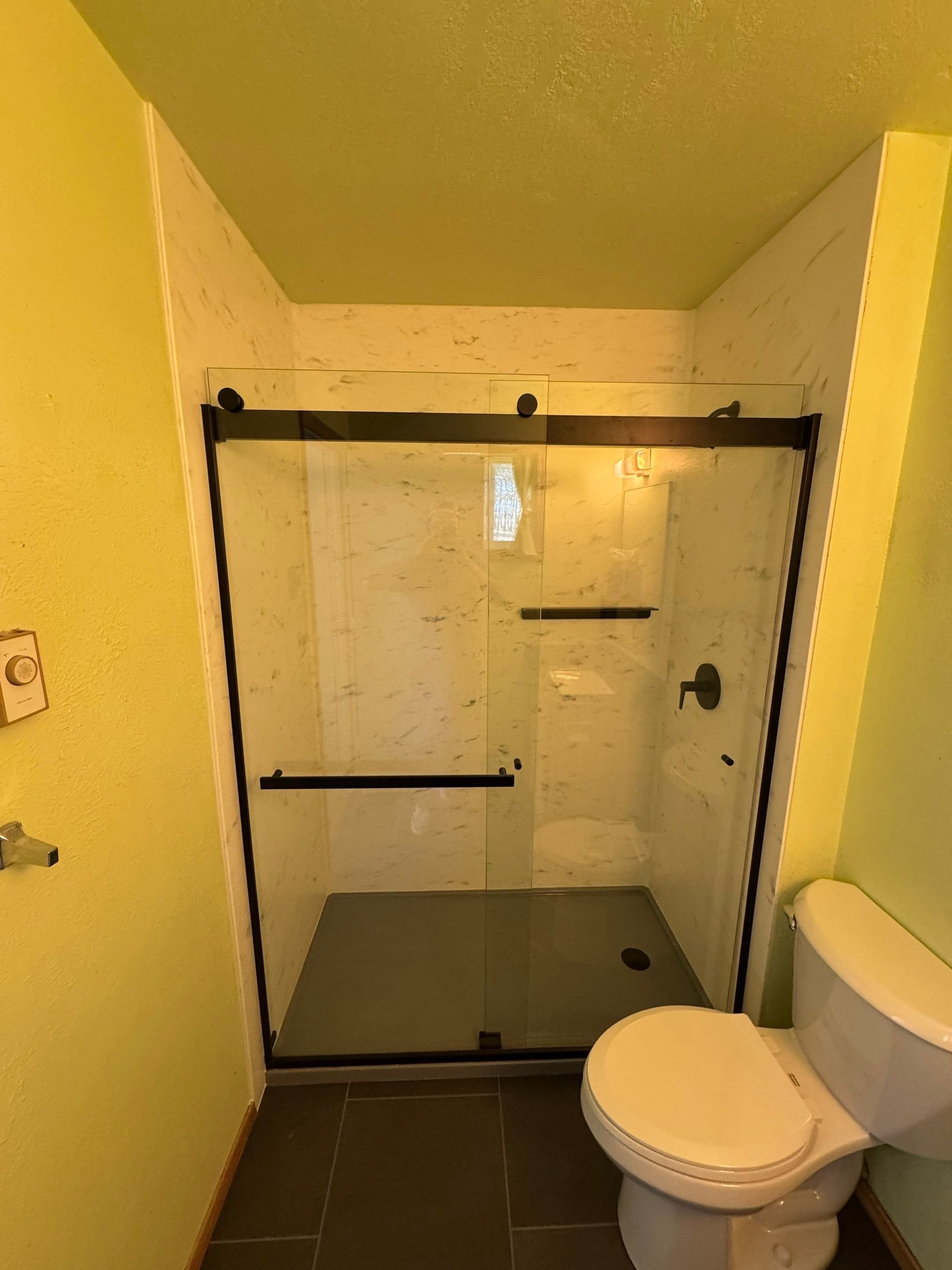 Modern walk-in shower remodel in Pagosa Springs on Shenandoah Road with sliding glass enclosure, waterproof wall panels, and upgraded fixtures