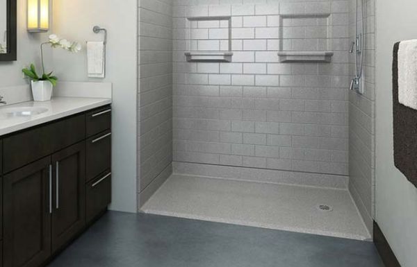Zero threshold walk-in shower with subway tile walls, recessed shelves, grab bars and handheld sprayer