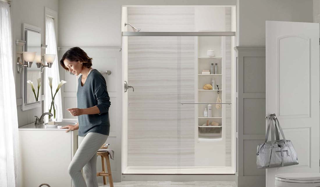 Image of woman relaxing in her newly remodeled bathroom and LuxStone shower remodel