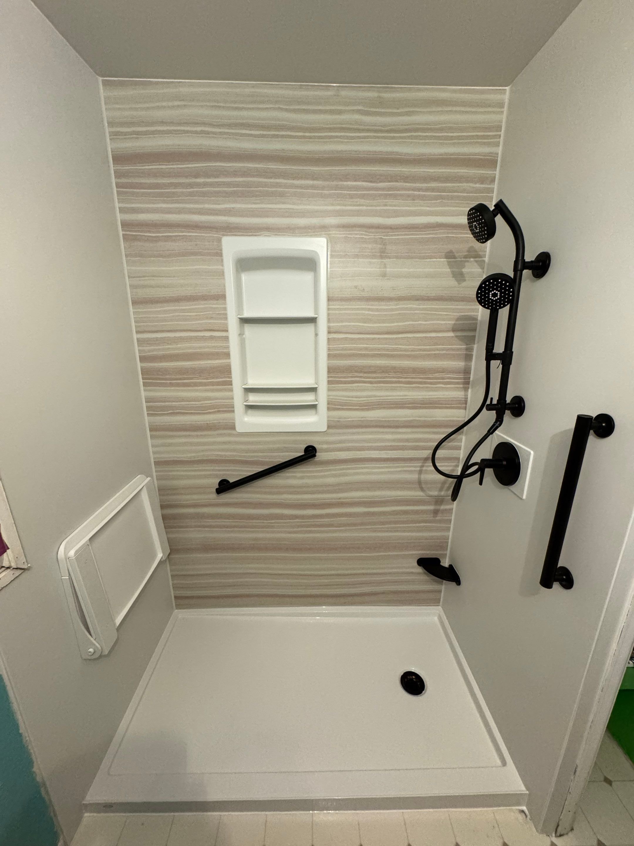 Accessible walk-in shower remodel in Aurora, CO with grab bars, handheld shower system, wall niche, and non-slip shower base