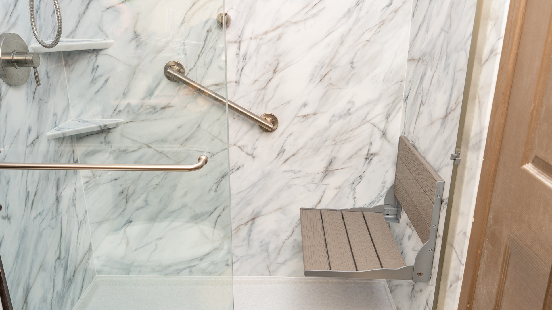 Accessible walk-in shower with low-threshold entry, grab bar, built-in seat and handshower for aging in place