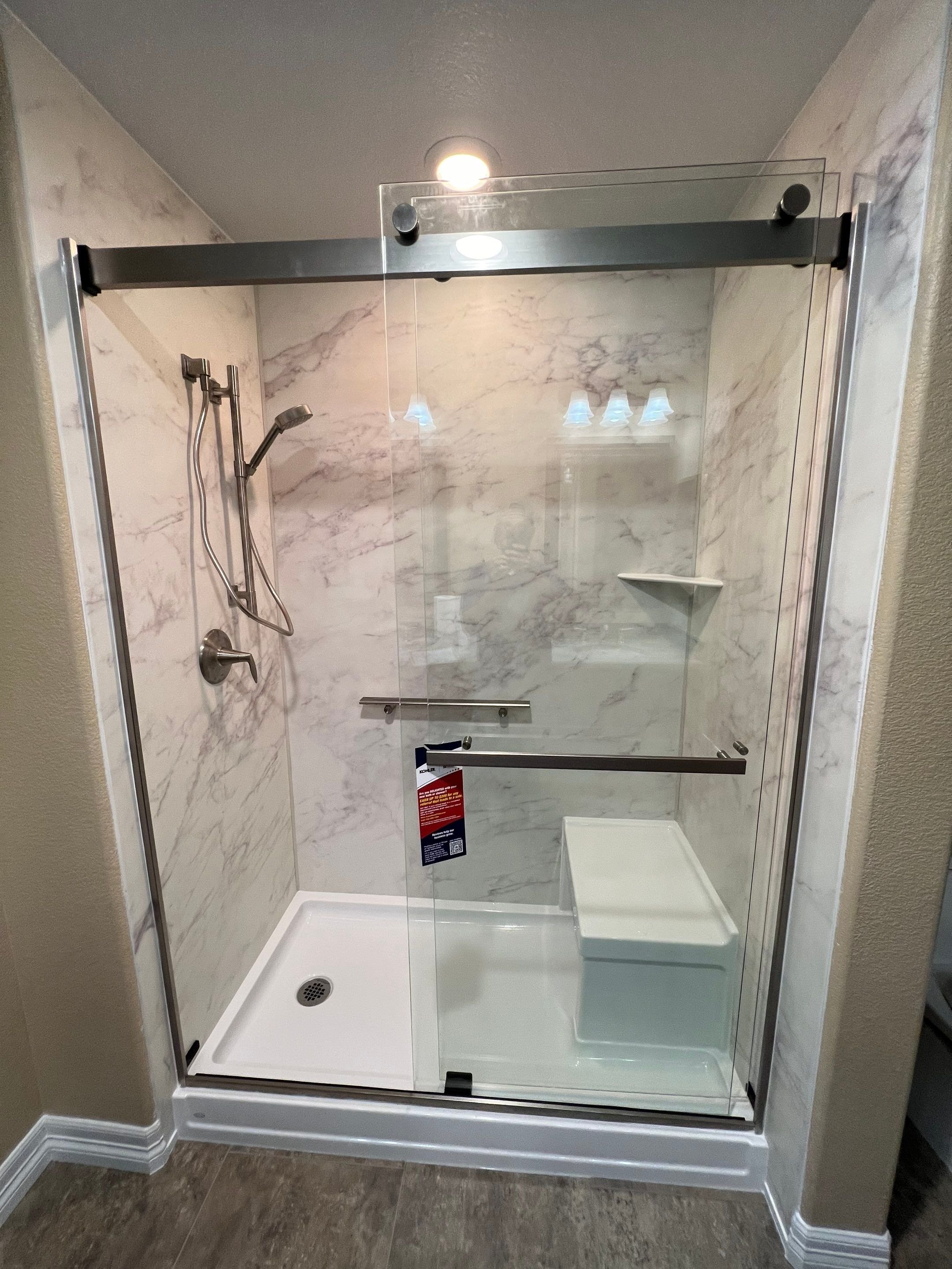 Thornton bathroom remodel on Xenia Street showing a walk-in shower installation with glass enclosure, upgraded lighting, and easy-clean wall panels.