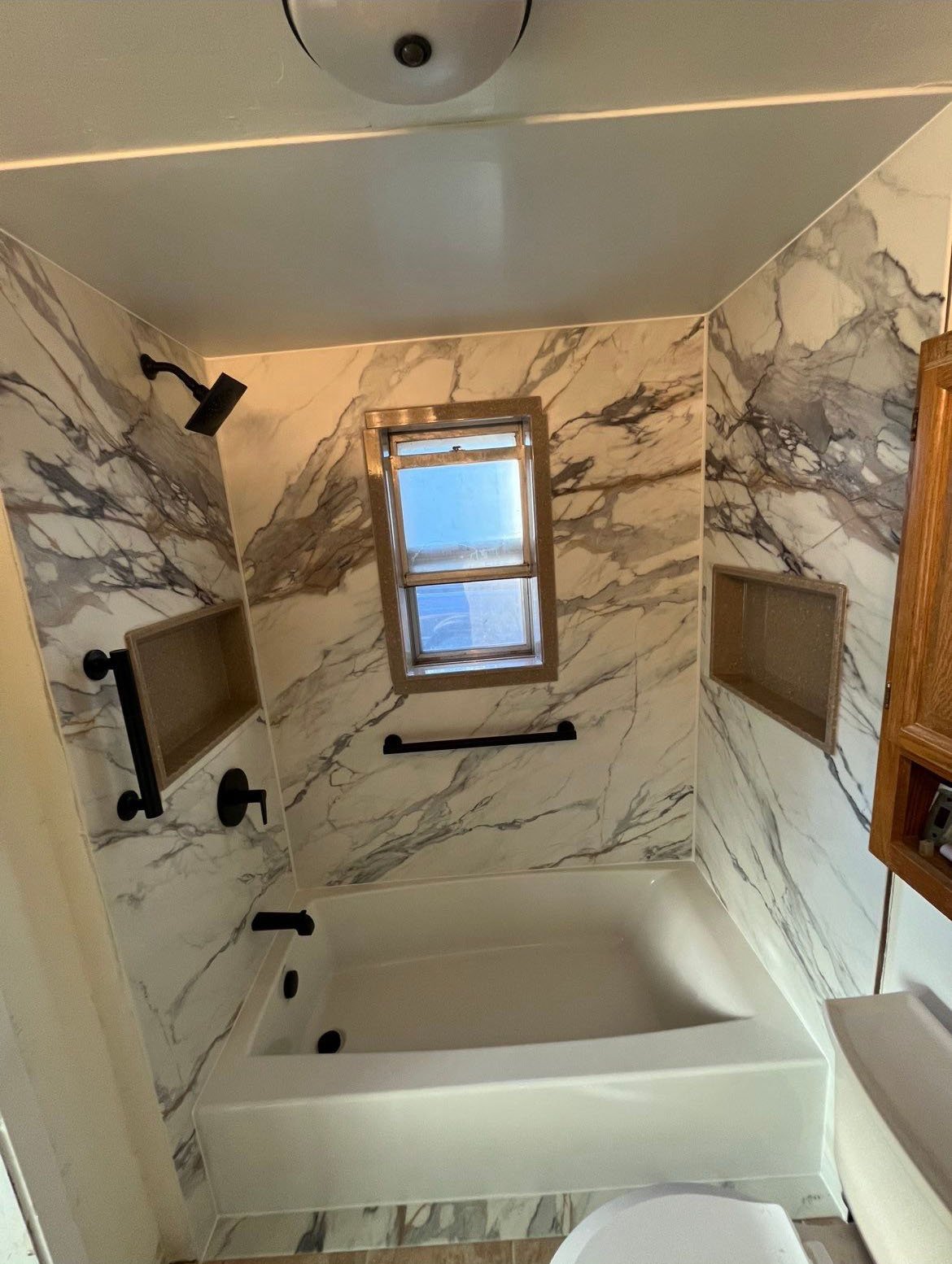 Bathtub remodel completed on Yukon Street in Lakewood featuring a deep soaking tub, integrated shelving, durable wall surrounds, and finishes designed for Front Range conditions.