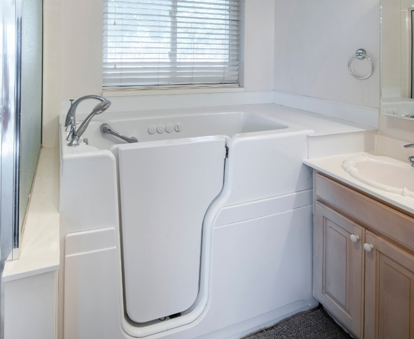 Walk-in tub with low step-in entry, built-in seat, and grab bars in a modern bathroom designed for safe aging in place