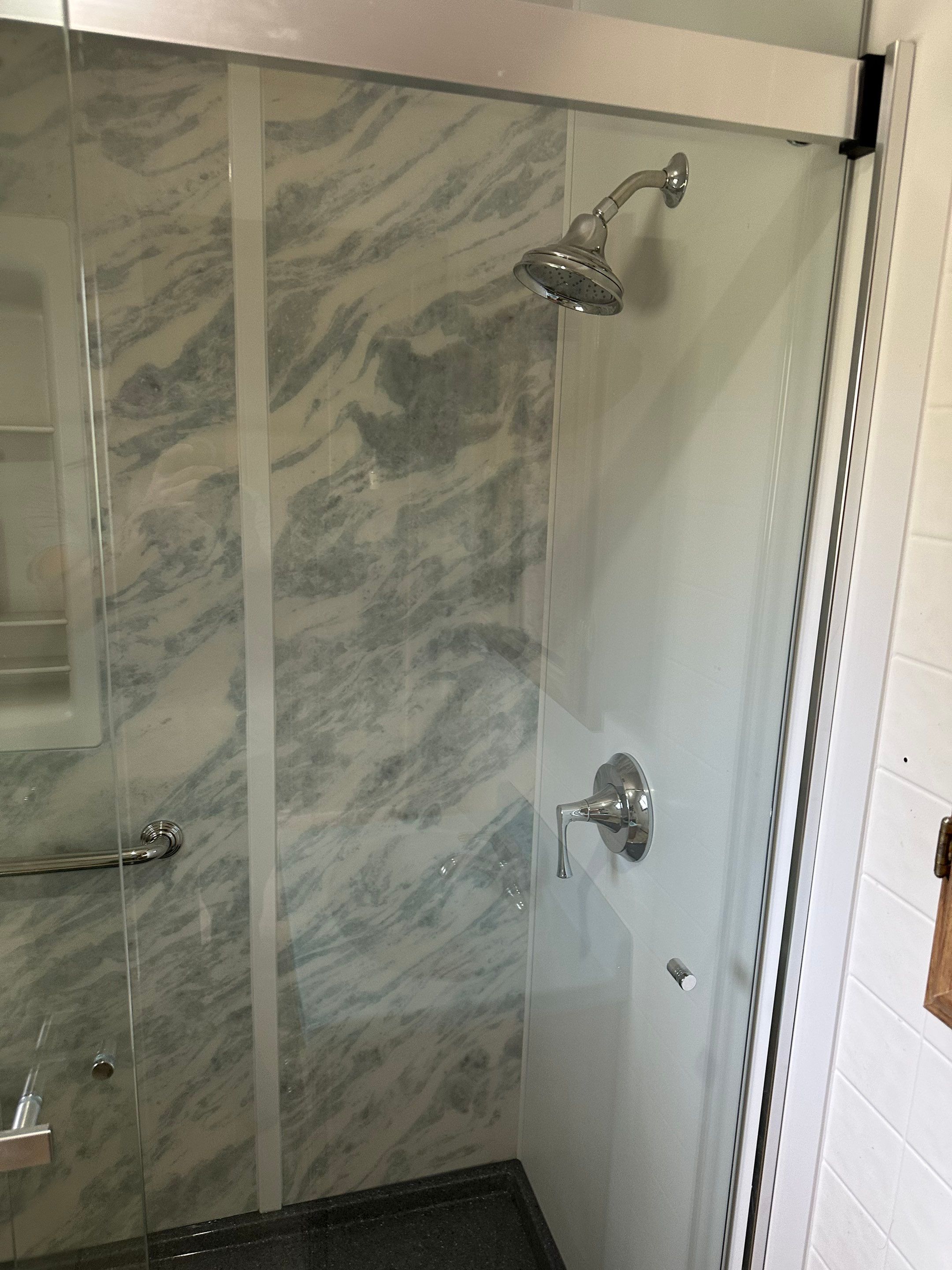 Kohler chrome shower head and sliding glass shower door with Onyx base in Alamosa, CO